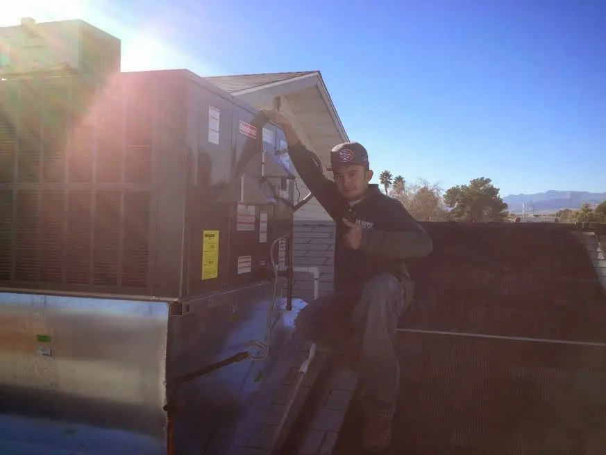 HVAC technician performing Heat Pump Repair on a rooftop unit in Parole